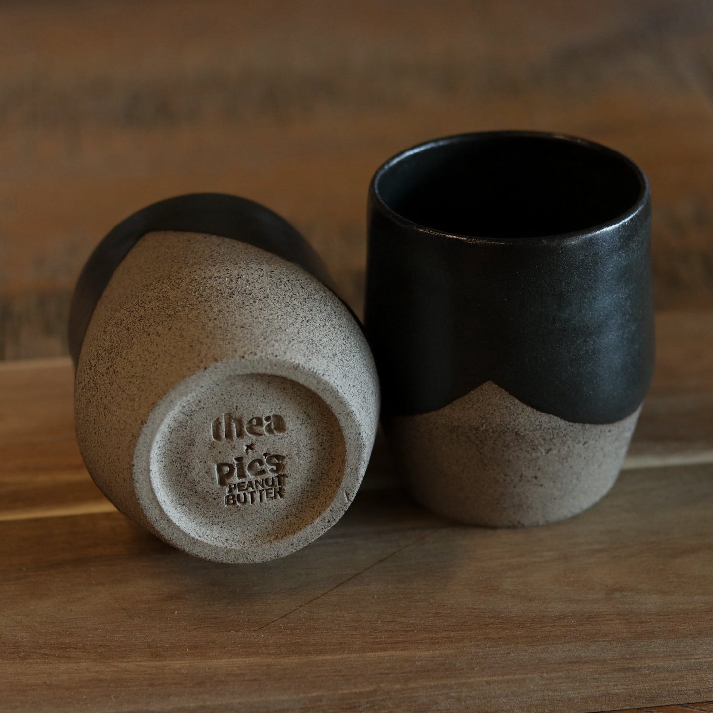 Two ceramic cups with a gradient finish on a wooden surface