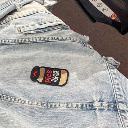 Ironing a patch on a denim jacket with a close-up of the iron.